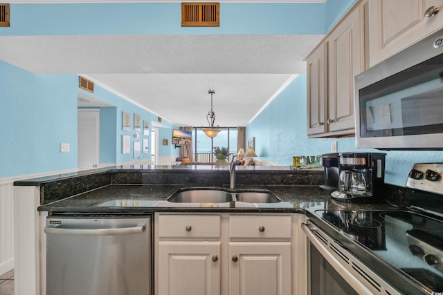 9400 Shore Dr Unit 722, Myrtle Beach, SC 29572 - kitchen featuring appliances with stainless steel finishes, dark stone countertops, a textured wall, decorative light fixtures, and a peninsula