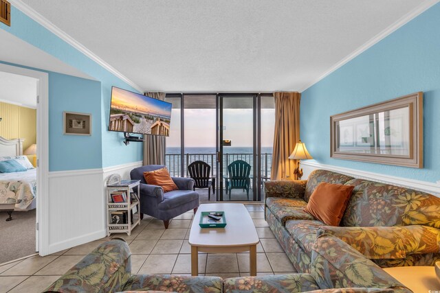 9400 Shore Dr Unit 722, Myrtle Beach, SC 29572 - living room featuring crown molding, tile patterned floors, floor to ceiling windows, a wainscoted wall, and a textured ceiling