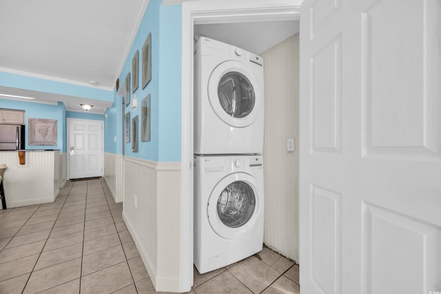 9400 Shore Dr Unit 722, Myrtle Beach, SC 29572 - washroom featuring stacked washing machine and dryer, light tile patterned floors, and wainscoting