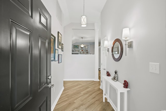 entryway with baseboards, light wood-type flooring, vaulted ceiling, a ceiling fan, and visible vents