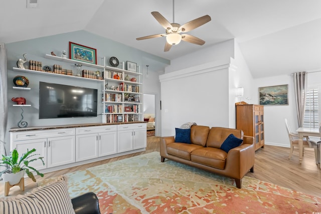 living room featuring baseboards, light wood finished floors, ceiling fan, and vaulted ceiling