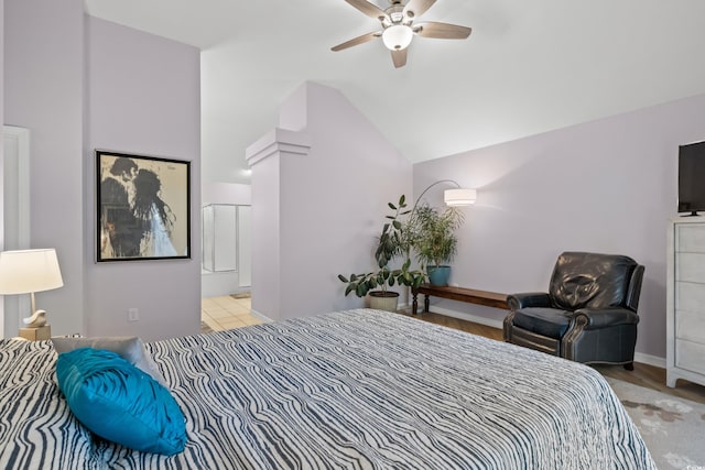 bedroom featuring a ceiling fan, ensuite bath, and lofted ceiling