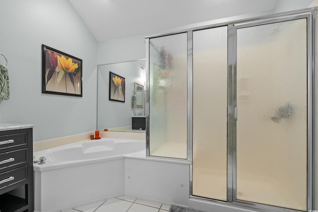 bathroom with a bath, vanity, tile patterned flooring, vaulted ceiling, and a stall shower