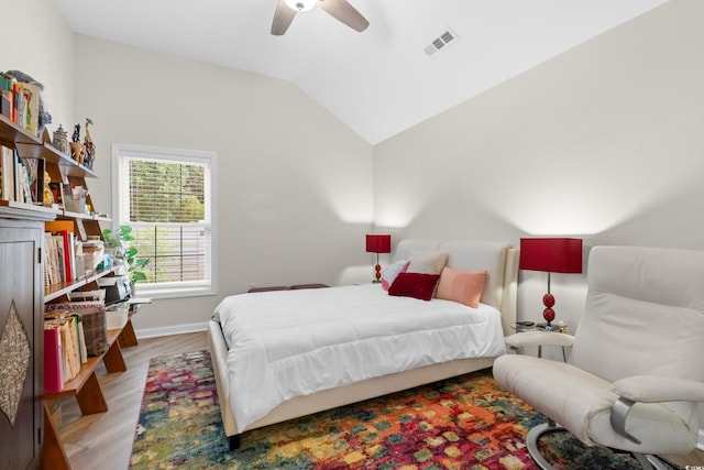 bedroom featuring ceiling fan, visible vents, lofted ceiling, light wood finished floors, and baseboards