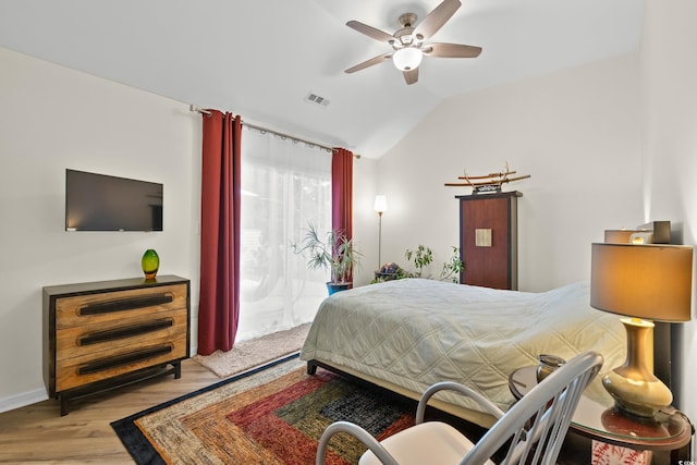 bedroom featuring wood finished floors, ceiling fan, vaulted ceiling, and visible vents