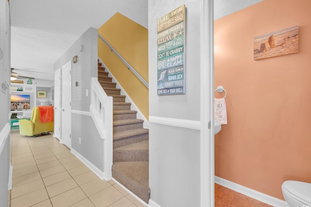 stairway featuring tile patterned flooring and baseboards