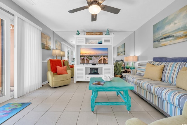 tiled living area featuring a fireplace and ceiling fan