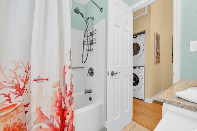 full bathroom with shower / tub combo, stacked washer and clothes dryer, and tile patterned floors