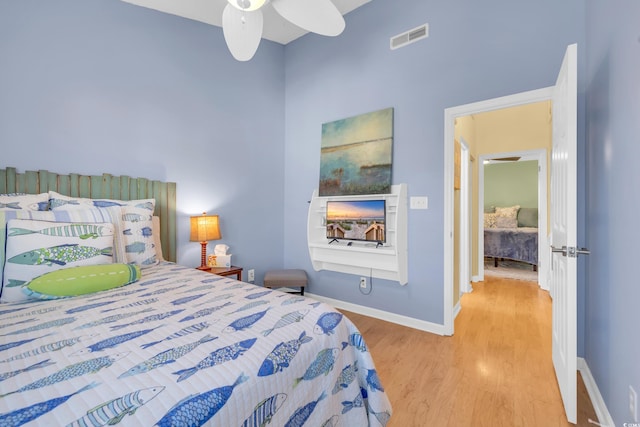 bedroom featuring wood finished floors, visible vents, and baseboards