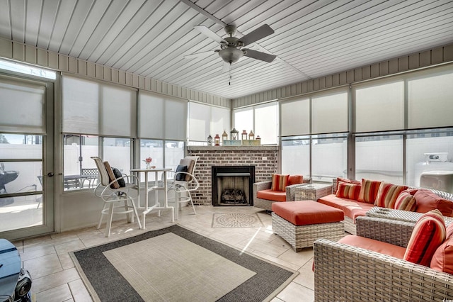 sunroom with ceiling fan and a fireplace