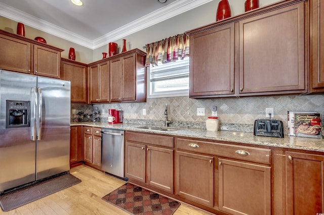 kitchen with stainless steel appliances, crown molding, a sink, and tasteful backsplash