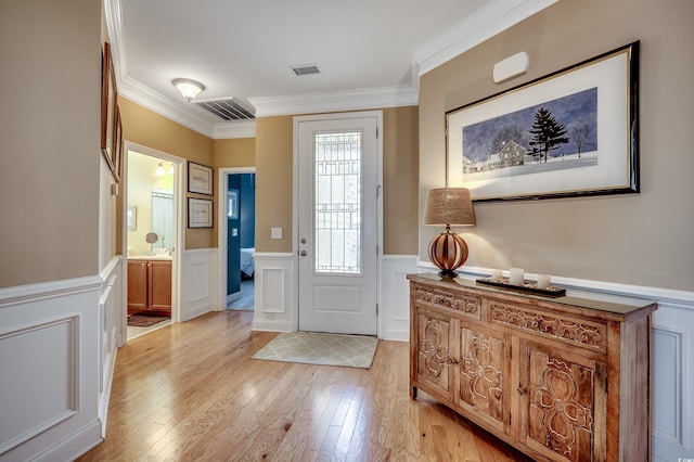 entryway featuring ornamental molding, visible vents, and light wood finished floors