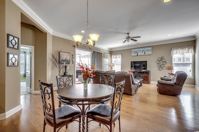 dining area with baseboards, ornamental molding, ceiling fan with notable chandelier, light wood-type flooring, and recessed lighting