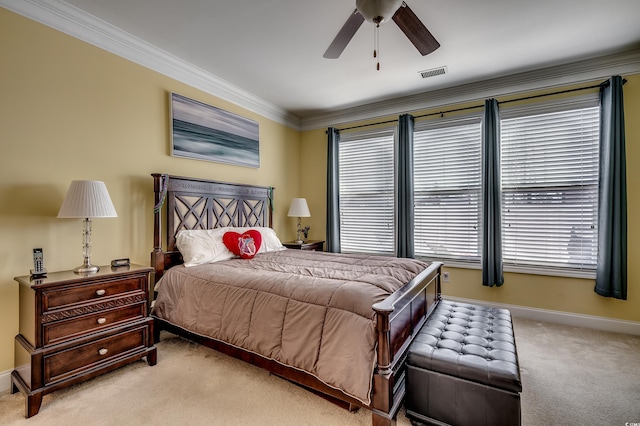 carpeted bedroom featuring a ceiling fan, baseboards, visible vents, and crown molding