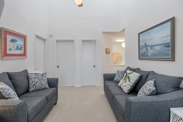 living room with a high ceiling and light carpet