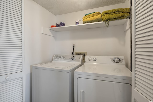 clothes washing area featuring laundry area, a textured ceiling, and separate washer and dryer