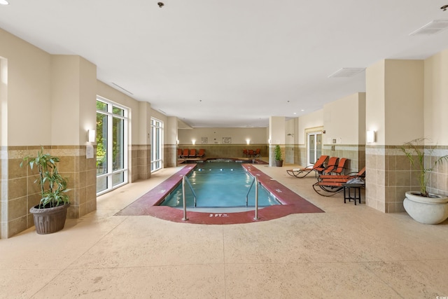 indoor community pool with a hot tub