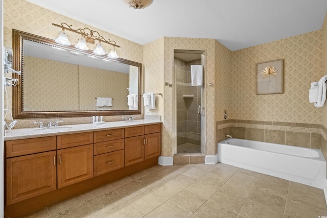 bathroom with a shower stall, a bath, double vanity, tile patterned floors, and wallpapered walls