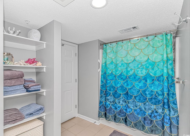 bathroom featuring tile patterned flooring, visible vents, a textured ceiling, and a shower with shower curtain