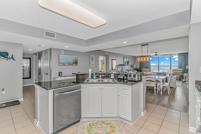 kitchen with dark countertops, visible vents, stainless steel dishwasher, and light tile patterned floors