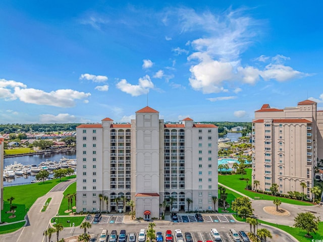 view of building exterior featuring a water view and uncovered parking