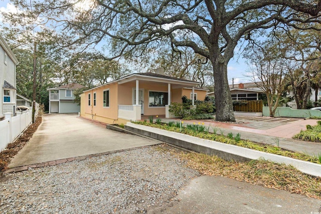 single story home with driveway, fence, and stucco siding