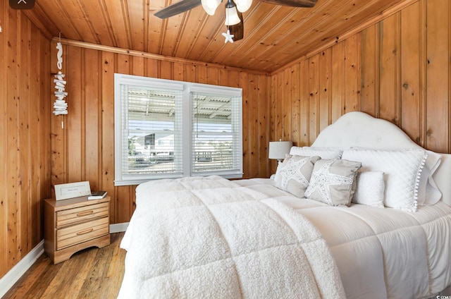 bedroom featuring wooden ceiling, wooden walls, and light wood finished floors