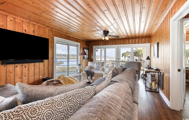 living room featuring wood walls, plenty of natural light, wood finished floors, and french doors