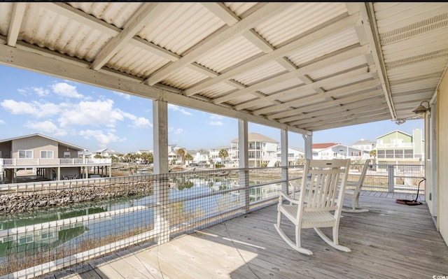 wooden terrace with a water view and a residential view