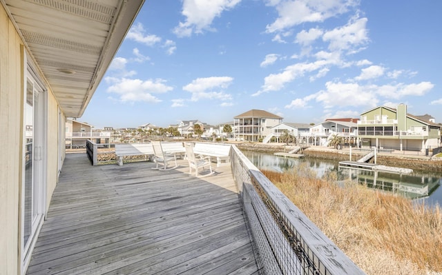 wooden terrace featuring a residential view and a water view