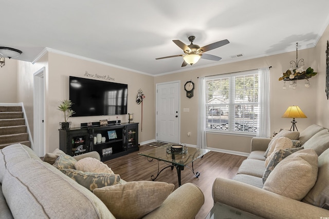 living area featuring wood finished floors, visible vents, baseboards, stairs, and ornamental molding