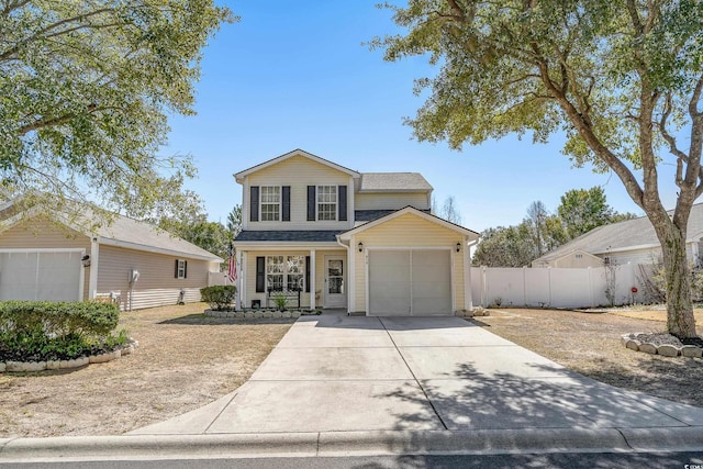 traditional home featuring a garage, fence, and driveway