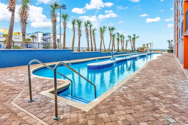 community pool featuring a patio area and a hot tub