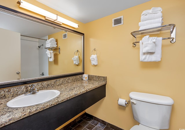 bathroom featuring toilet, baseboards, visible vents, and walk in shower