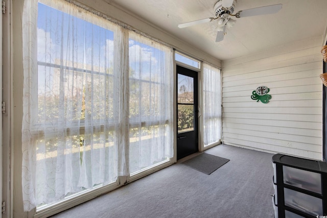 unfurnished sunroom with a ceiling fan