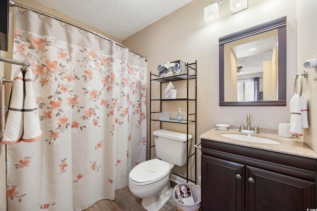 bathroom featuring wood finished floors, a textured ceiling, toilet, and vanity