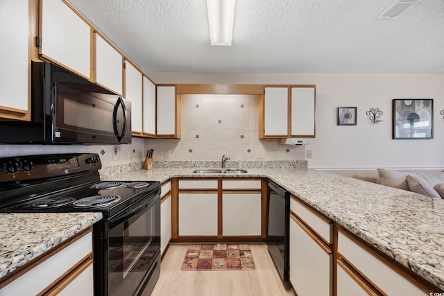 kitchen with visible vents, light wood-style floors, a sink, a textured ceiling, and black appliances