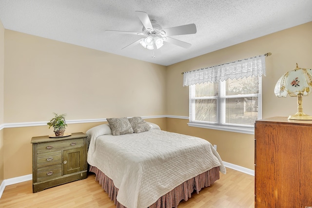 6634 Cinnamon Fern Ln, Myrtle Beach, SC 29588 - bedroom with baseboards, ceiling fan, light wood-style flooring, and a textured ceiling