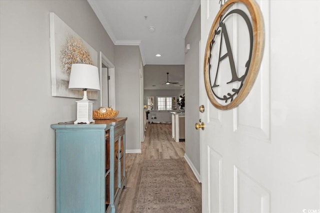 hall featuring baseboards, recessed lighting, wood finished floors, and crown molding