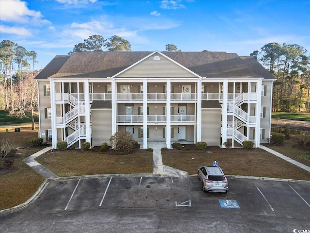 view of property with uncovered parking and stairway