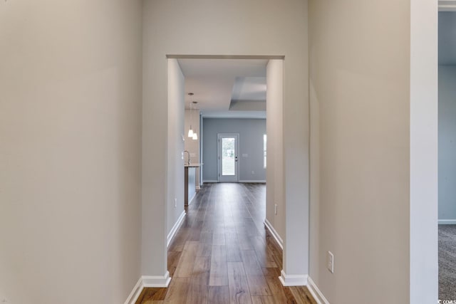 hallway with baseboards and wood finished floors