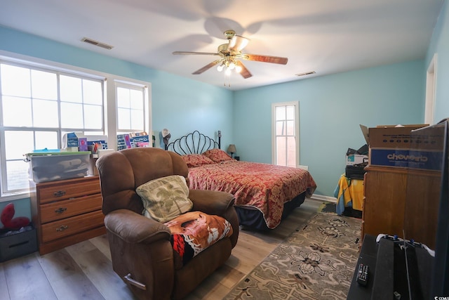 bedroom featuring visible vents, ceiling fan, and wood finished floors