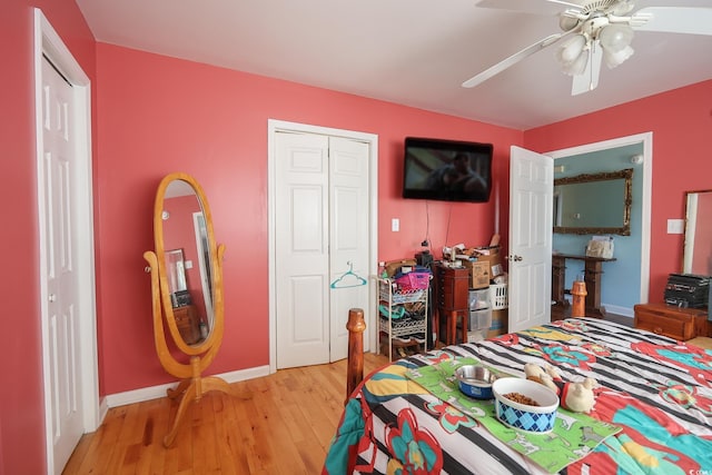 bedroom with light wood-style flooring, a ceiling fan, baseboards, and a closet