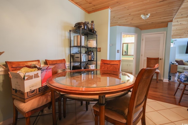 dining area featuring light tile patterned floors and wood ceiling