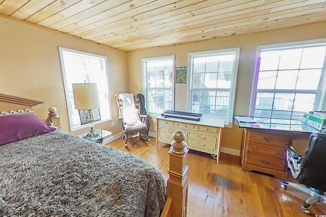 bedroom with wood ceiling, light wood-style floors, and baseboards