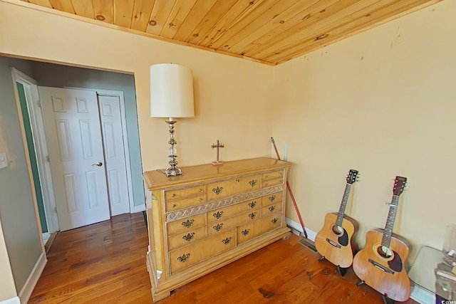 interior space with baseboards, wood finished floors, and wooden ceiling