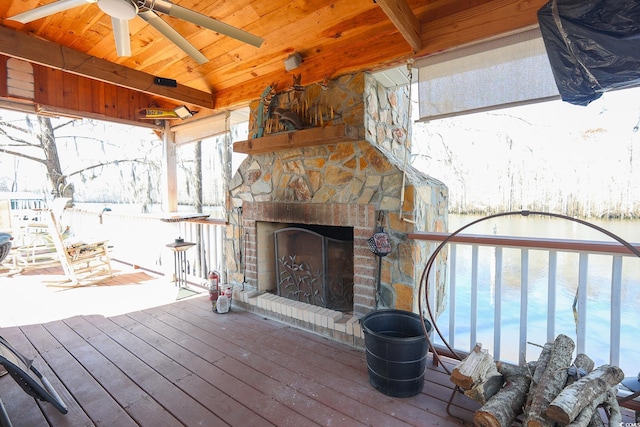 deck featuring a ceiling fan and a fireplace with raised hearth