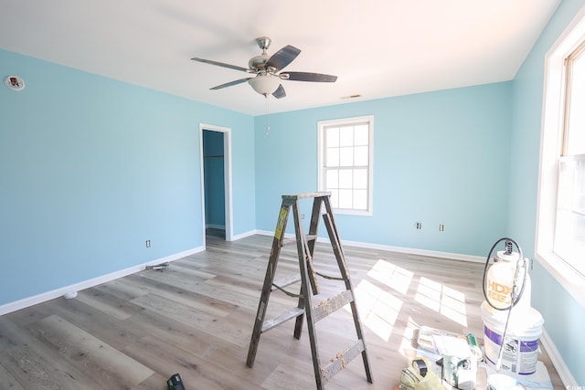 spare room featuring visible vents, a ceiling fan, baseboards, and wood finished floors