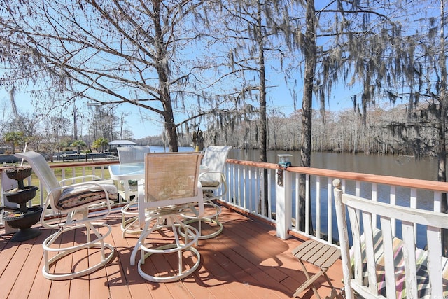 wooden deck featuring outdoor dining area and a water view