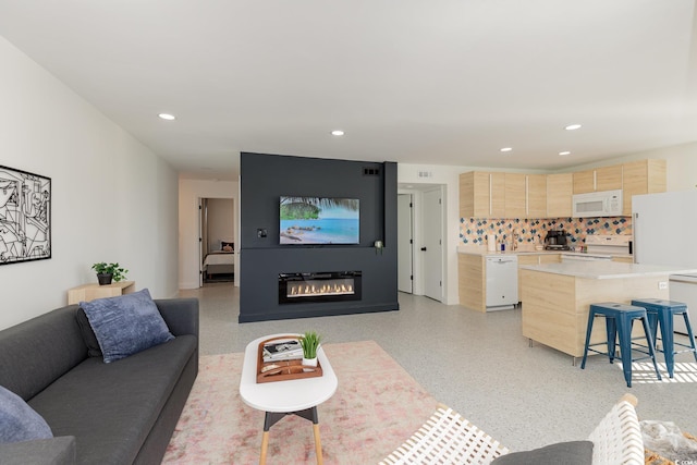 living room with recessed lighting and a glass covered fireplace